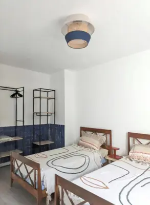 a room with two beds and a light at Appartement spacieux à Cargèse avec terrasse vue mer in Cargèse