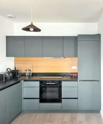 a kitchen with gray cabinets and a black oven at Appartement spacieux à Cargèse avec terrasse vue mer in Cargèse