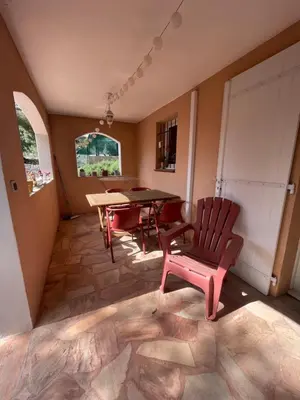 a dining room with a table and a red chair at Appartement meublé Porto vecchio in Porto-Vecchio