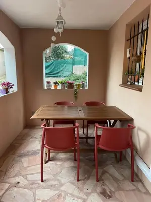 a dining room with a wooden table and red chairs at Appartement meublé Porto vecchio in Porto-Vecchio
