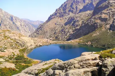 a large blue lake in the middle of a mountain at Corte tres beau T2 neuf hyper centre 4 personnes calme et lumineux wifi lave linge in Corte