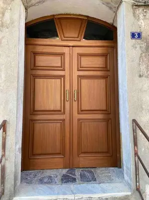 a large wooden door in a stone building at Corte tres beau T2 neuf hyper centre 4 personnes calme et lumineux wifi lave linge in Corte