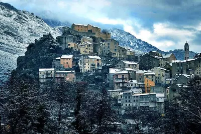 a bunch of buildings on a mountain with snow on it at Corte tres beau T2 neuf hyper centre 4 personnes calme et lumineux wifi lave linge in Corte
