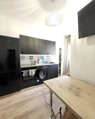 a kitchen with a washer and dryer and a table at Corte tres beau T2 neuf hyper centre 4 personnes calme et lumineux wifi lave linge in Corte