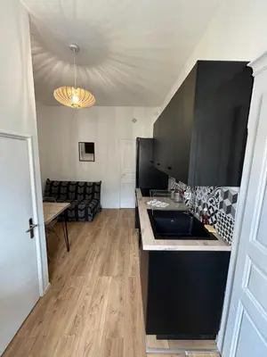 a kitchen with black cabinets and a counter top at Corte tres beau T2 neuf hyper centre 4 personnes calme et lumineux wifi lave linge in Corte