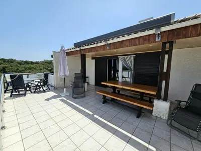 a patio with a wooden bench on a roof at Maison Le Guetali in Zonza