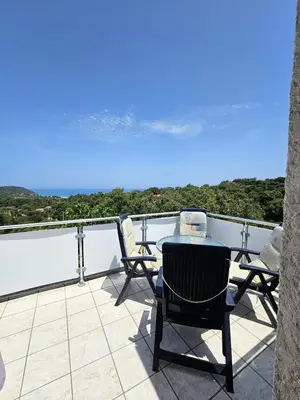 a patio with chairs and a table on a balcony at Maison Le Guetali in Zonza