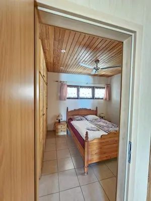 a bedroom with a bed with a wooden ceiling at Maison Le Guetali in Zonza