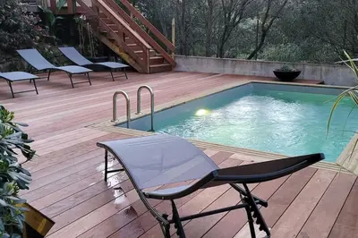 a deck with chairs next to a swimming pool at Casa Marcelli 3 in Porto-Vecchio