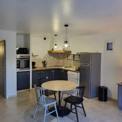 a kitchen with a table and chairs and a refrigerator at Casa Marcelli 3 in Porto-Vecchio