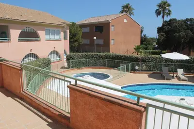 a building with a swimming pool next to a building at Trilocale in residence con piscina a 200 m dal mare in Linguizzetta
