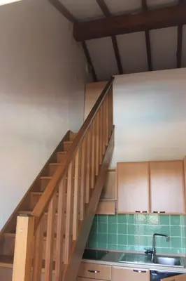 a kitchen with a sink and a wooden staircase at Trilocale in residence con piscina a 200 m dal mare in Linguizzetta