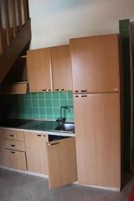 a kitchen with a sink and a refrigerator at Trilocale in residence con piscina a 200 m dal mare in Linguizzetta