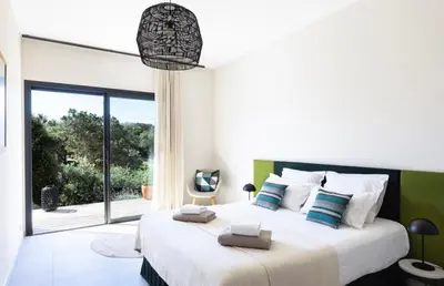 a bedroom with a large bed and a large window at A Liccia in Pianottoli-Caldarello