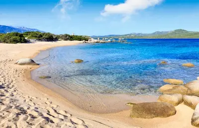 a sandy beach with rocks and the ocean at A Liccia in Pianottoli-Caldarello