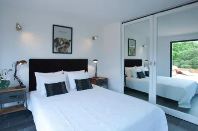 a bedroom with two beds and a large window at Casa Julia in Zonza