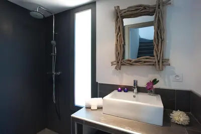 a bathroom with a white sink and a mirror at Casa Julia in Zonza