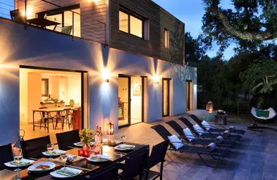 a patio with tables and chairs and a house at Casa Julia in Zonza
