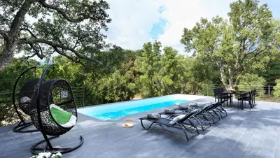 a patio with a table and chairs next to a pool at Casa Julia in Zonza
