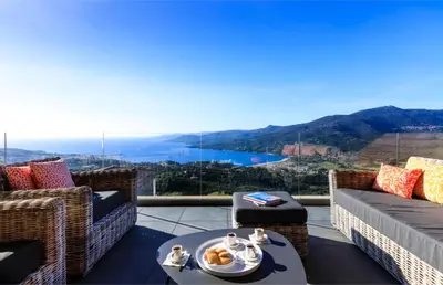 a balcony with two couches and a table with food at Villa Supranu in Viggianello