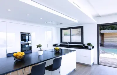 a kitchen with white cabinets and a black counter top at Villa Supranu in Viggianello