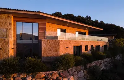 a house on a hill with a stone wall at Villa Supranu in Viggianello
