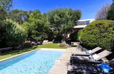 a swimming pool with lounge chairs next to a house at Villa Bule in Porto-Vecchio