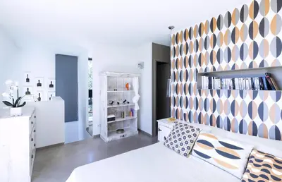 a bedroom with a white bed and a large wall at Villa Bule in Porto-Vecchio