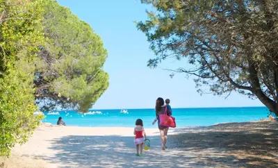 a woman and a child walking on the beach at Villa Bule in Porto-Vecchio