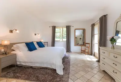 a bedroom with a white bed and a mirror at I Vaddi in Porto-Vecchio