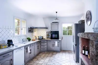 a kitchen with white cabinets and a refrigerator at I Vaddi in Porto-Vecchio