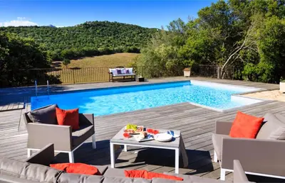 a patio with a pool and a table and chairs at I Vaddi in Porto-Vecchio