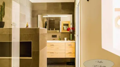 a bathroom with a sink and a mirror at Villa U Scopu, 6 pers, piscine chauffée, 10 mn plage en voiture in Lecci