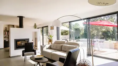 a living room with a couch and a fireplace at Villa U Scopu, 6 pers, piscine chauffée, 10 mn plage en voiture in Lecci