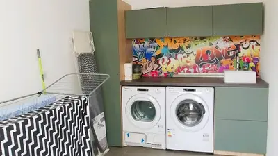 a laundry room with a washing machine and a colorful wall at Villa U Scopu, 6 pers, piscine chauffée, 10 mn plage en voiture in Lecci