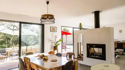 a dining room with a table and a fireplace at Villa U Scopu, 6 pers, piscine chauffée, 10 mn plage en voiture in Lecci