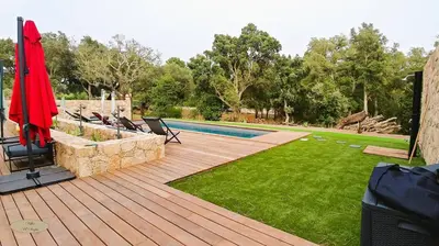 a backyard with a wooden deck and a swimming pool at Villa U Scopu, 6 pers, piscine chauffée, 10 mn plage en voiture in Lecci
