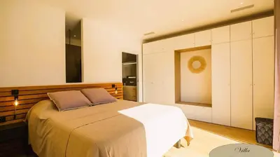 a bedroom with a large bed with white cabinets at Villa U Scopu, 6 pers, piscine chauffée, 10 mn plage en voiture in Lecci