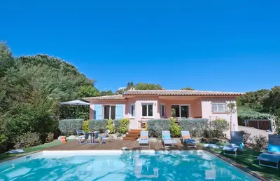 a villa with a swimming pool in front of a house at Pinarello Beach House in Porto-Vecchio