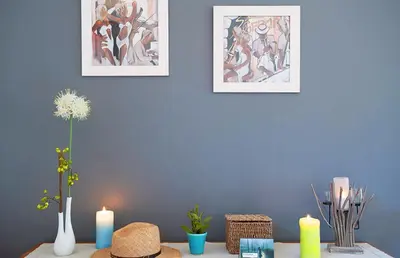 a table with two candles and two pictures on a wall at Pinarello Beach House in Porto-Vecchio