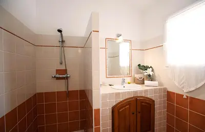 a bathroom with a sink and a mirror at Pinarello Beach House in Porto-Vecchio