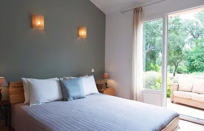 a bedroom with a bed and a large window at Pinarello Beach House in Porto-Vecchio