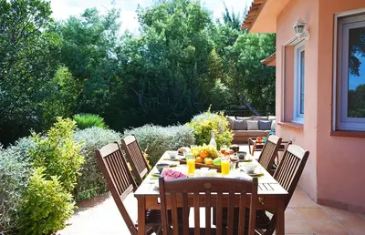 a wooden table with fruit on it on a patio at Pinarello Beach House in Porto-Vecchio