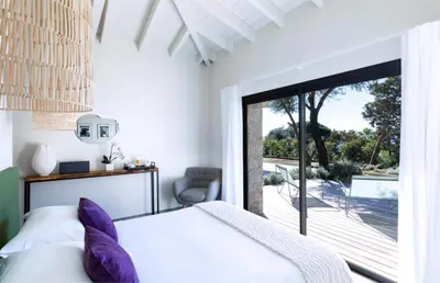 a bedroom with a bed with purple pillows at The Beach House in Olmeto