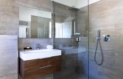 a bathroom with a sink and a glass shower at The Beach House in Olmeto