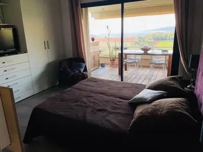 a bedroom with a bed and a view of a patio at appartement Vue mer époustouflante in Propriano