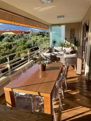 a balcony with two tables and chairs on a balcony at appartement Vue mer époustouflante in Propriano
