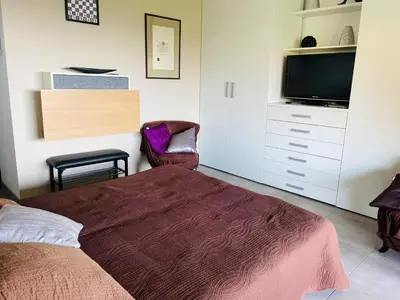 a bedroom with a bed and a flat screen tv at appartement Vue mer époustouflante in Propriano