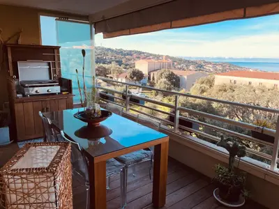 a balcony with a table and a view at appartement Vue mer époustouflante in Propriano