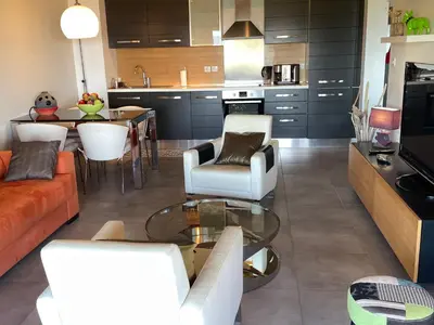 a kitchen and living room with a couch and a table at appartement Vue mer époustouflante in Propriano